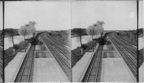 Looking W. (near Clyde, N.Y.) from R.R. Signal Bridge to N.Y.C. R.R. tracks and Barge Canal showing long freight train loaded with automobiles