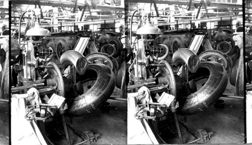 Stripping tire from collapsible core (40x8 tire). It is now ready for curing, Akron, Ohio