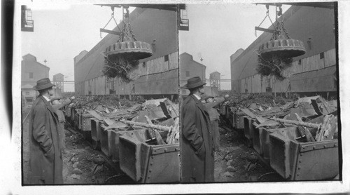 Magnet picking up steel scraps to be re-melted in blast furnace. Homestead, Penna