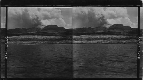 Grin and threatening Mont Pelee from the bay the portion of St. Pierre most deeply buried in volcanic mud and ashes, Martinique, Lesser Antilles