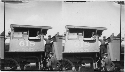 Mrs. Harding acting as fireman while her husband drove his engine, fireman standing in cab, conductor in foreground