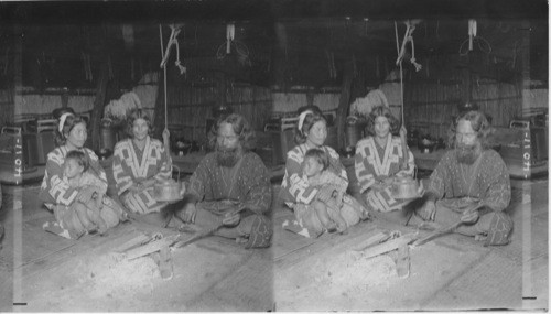 Interior of an Ainu home, showing owner and family. Island of Yezo, Japan