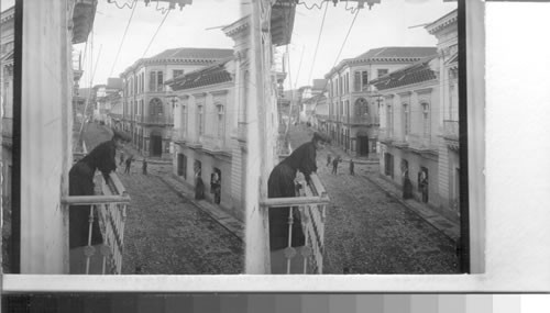 A pretty neighbor taking the air on a balcony overlooking Bolivar St. Quito, Ecuador