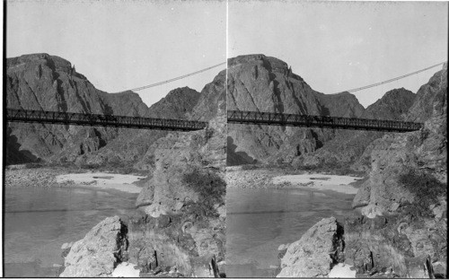 A trail party on the Kaibab Suspension Bridge looking down Colorado river. Grand Canyon, Ariz