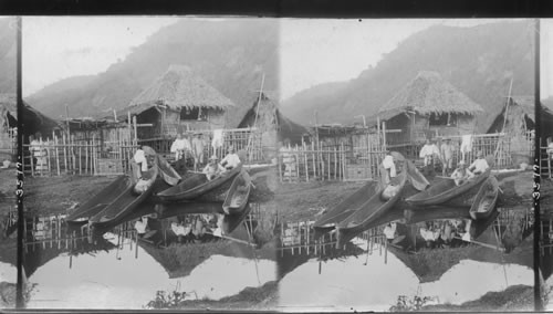 A fisherman's house and primitive dug-out boats. Philippine Islands