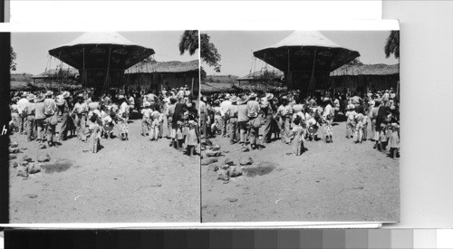 Sunday market, held weekly in the little old town of Olocuilta about 30 miles southeast of San Salvador, is always a bright and busy scene. however, on occasion something special is added as was the case on this Sunday - a special feast day, when the portable carousel was enjoyed by both young and old. The Indians from all about the countryside some miles each week for this market where they bargain, buy and sell, and enjoy the exchange of news with their neighbors. Olocuilta, El Salvador, C.A