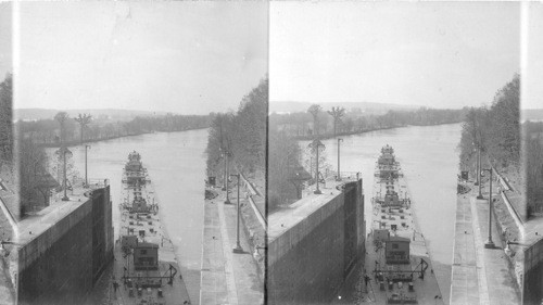 Boat and barges leaving the lock going down the river with boat and barges of oil waiting to enter the lock. ? Tennessee, Georgia, Alabama