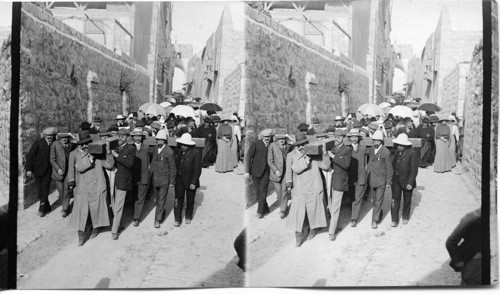 Devout pilgrims carrying a great cross thru the Via Dolorosa, Jerusalem, Palestine