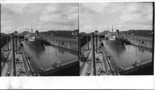 Miraflores Locks, Panama Canal. Miraflores Locks are the first from the Pacific side of the Panama Canal. Looking down from the Miraflores Bridge on the east chamber as an Atlantic-bound ship goes through. Workers cross the lock gates in the foreground to the west chambers, which at this time are closed to traffic because of the annual cleaning of all lock chambers. the tops of lock gates are all used for cross-overs when closed before of after the passage of ships