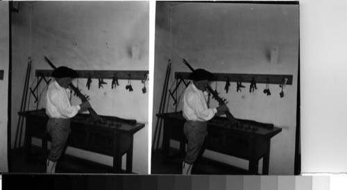 ARMORER - Powder Magazine interior. Armory room. "Guardsman" preparing a musket. Williamsburg, Virginia