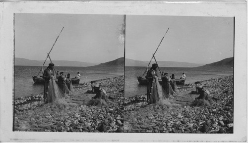 Fisherman mending their nets on the Shore of the Sea of Glailee Palestine