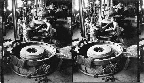 Breaking out tire from mold. This is the curing machine, Akron, Ohio