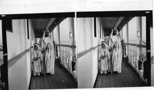 170 Sheikh of Sharjah with his son on board M.S. Dwarka. Sharjah is a small independent state south of Bahrein (marked on every larger scale map). Note the “agal” (golden cords) on the head of the Sheikh. Only a sheikh is entitled to wear the golden agal