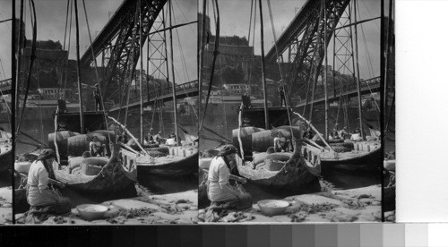 Produce bearing boats come to the market in Oporto come down the Duoro river. The Bridge of Dom Luis Primeiro. Oporto, Portugal