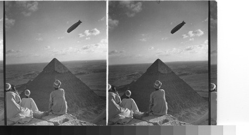 The Graf Zeppelin, noise pointing southward over the Sahara Sands, circles the Pyramids of Gizeh