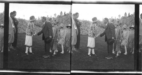 Pres. and Mrs. Coolidge shaking hands with delegations on the lawn of the Summer White House, (The State Game Lodge), South Dakota