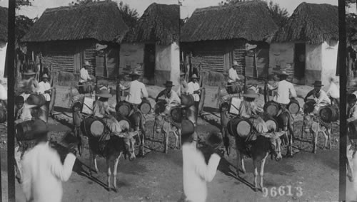 Water carriers and thatched-roof homes. Barranquilla, Columbia. S.A