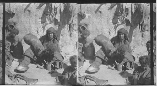 A Bedouin Woman churning with a Goatskin. Palestine