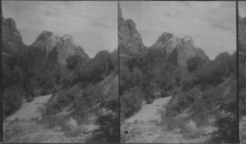 Majestic Spear Head, Cathedral and Angels Landing with road and car in foreground. Angel's Landing is low at right hand extreme view. Zion National Park. Utah