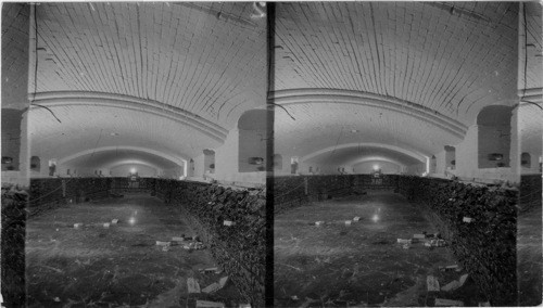 Interior of a Glass furnace which is being repaired. The floor is covered with a foot of cooled glass. When the furnace is working it contains four feet of Molten glass. While glass is flowing out of furnace is kept a a temperature of about 2600 Fh.[degrees Fahrenheit]. At the farthest end we see the small door from which the glass flows out. Ford Motor Plant, Detroit, Mich