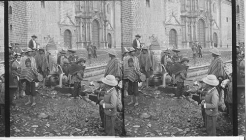 Drawing water from a fountain of curious design before old Spanish Cathedral. Cuzco. Peru