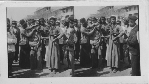 Street Barber Plying his Trade in the streets of Old Cairo, Egypt