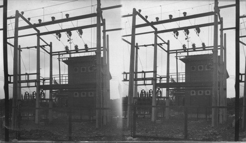 Side view of 44000 volt switching tower with transformer station in background. Hydro electric, C 18th Station. Petersborough, Ont