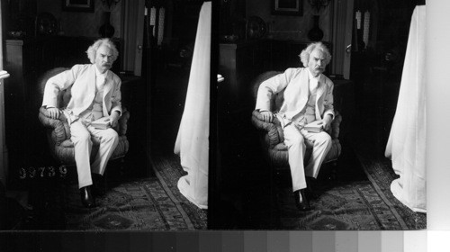 Mark Twain seated with Book