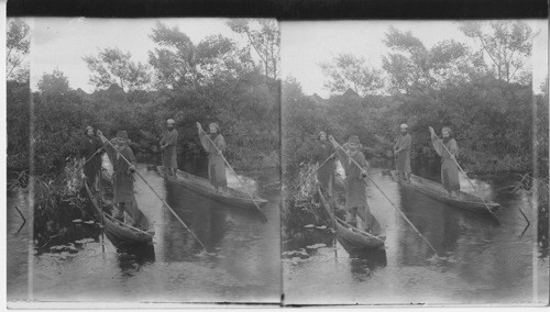 Ainu fisherman in their primitive boats, Yezo