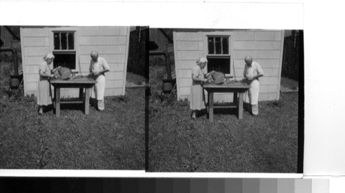 Gatlinburg, Tenn.: Two coppersmiths at work outside their little shop on their home property in the outskirts of Gatlinburg, which is the Tennessee entrance to their Great Smokies National Park