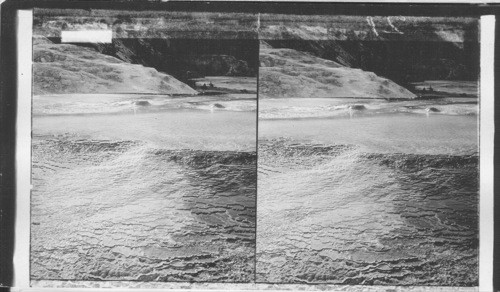 How an overflowing spring begins to build a terrace of geyserite deposit. Y.N.P., Wyoming