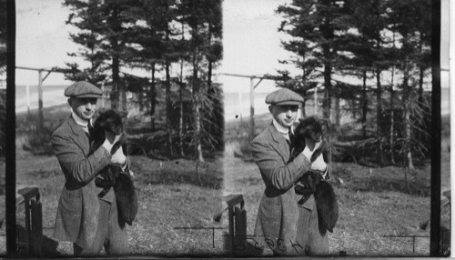 Showing Dr. Leo Frank holding a domesticated Silver Black Fox in his arms, Rosbank Fur Farms, Ltd. Southport, P.E. Island