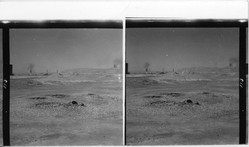 RING OF STONES IN THE FOREGROUND WITH (DIFFICULT TO SEE) SMALL FLAMES BURNING. THIS PLACE IS KNOWN AS BABA GURGUR THE FATHER OF FIRE FLAMES ARE BURNING (NATURAL GAS) SINCE MANY CENTURIES. WERE INSTRUMENTAL TO THE DISCOVERY OF OIL IN THE KIRKUK DISTRICT. IN THE BACKGROUND KIRKUK REFINERY