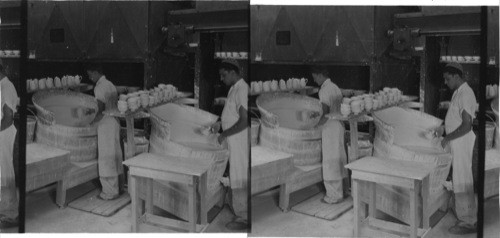 "Applying glaze to bisk." All ware is called "bisk" before it is glazed. "Lenox, inc." Makers of fine chinaware, Trenton, N.J