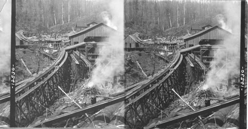 The lumber flume and the burning refuse. Characteristic sawmill, Cascade Mts