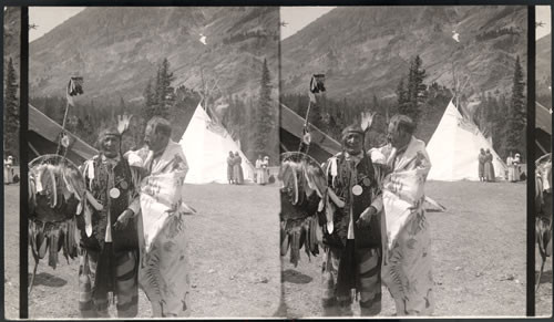 The Chief Medicine man member of Tribe wrapped in Historical Blackfeet Robe. Decorated robe and Blackfeet medicine man. Glacier National Park, Montana