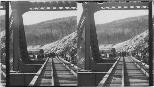 Scene shoeing train and crowd at end of Tetana Bridge. Driven gold spike, Alaska