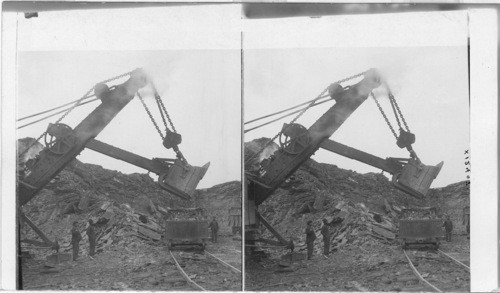 Large steam shovel loading cars in quarry with Portland Cement Rock. Fogelsville, Penna