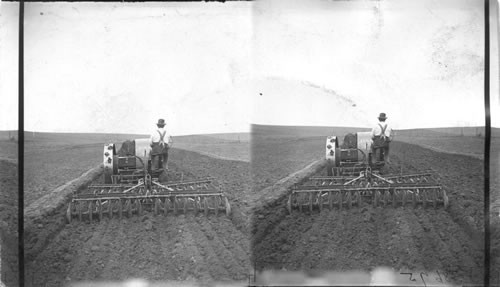 Making a good seed bed. Tractor drawing double disk and 3 section North (?) Harrows, S. Dak