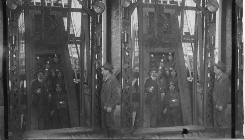 Cage with miers going down Creighton Mine, Ont