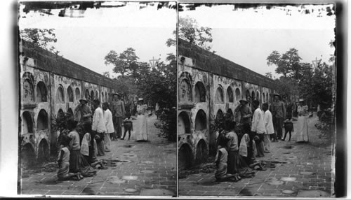 Praying for the souls of departed friends in a Manila Cemetery. P.I