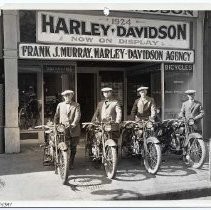 Four men with motorcycles in front of the Harley Dalvidson sales store at 508 J Street
