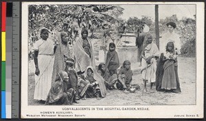 Woman standing with convalescents in a hospital garden, India, ca.1920-1940