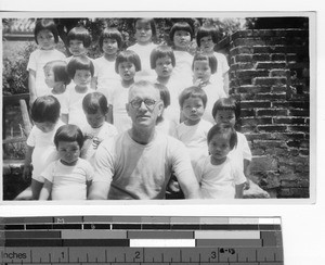 Fr. Kennelly with Maryknoll orphans at Luoding, China, 1948