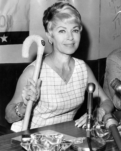 Lana Turner returns from Vietnam with cane