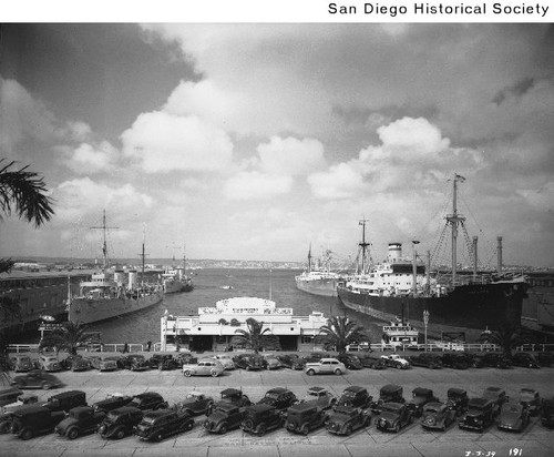 Several ships tied to two piers in San Diego Harbor