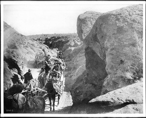 A desert stage going through a canyon heading towards Goldfield, Nevada, ca.1900