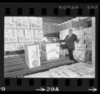 Pasta manufacturer Robert William, standing amid boxes of surplus products, Los Angeles, Calif., 1966