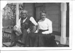 William and Leona Rosebrook sitting on their porch steps with a dog and cat at their farm on Mill Station Road in Sebastopol