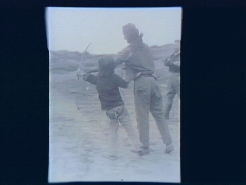 Native Americans; Man Teaching Boy to Shoot Bow and Arrow